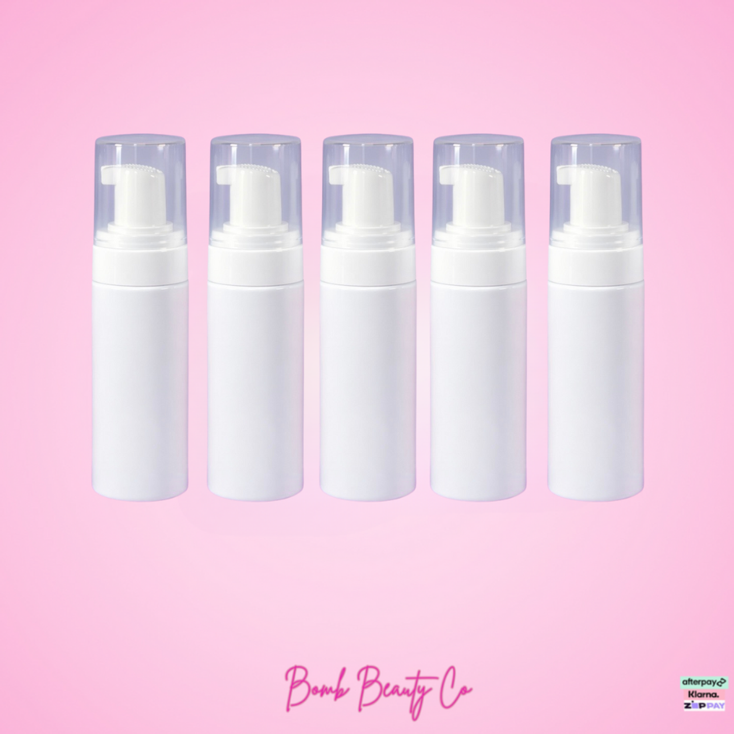Five white foam pumps on a pink background with 'Bomb Beauty Co' branding.