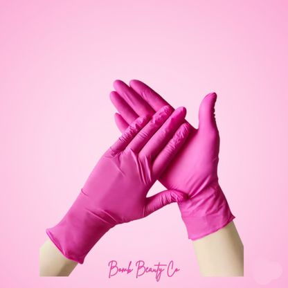 Pair of pink gloves on a pink background with 'Bomb Beauty Co' branding.