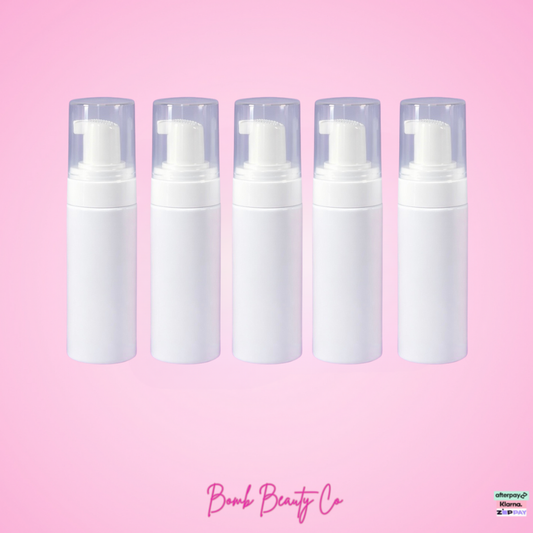 Five white foam pumps on a pink background with 'Bomb Beauty Co' branding.