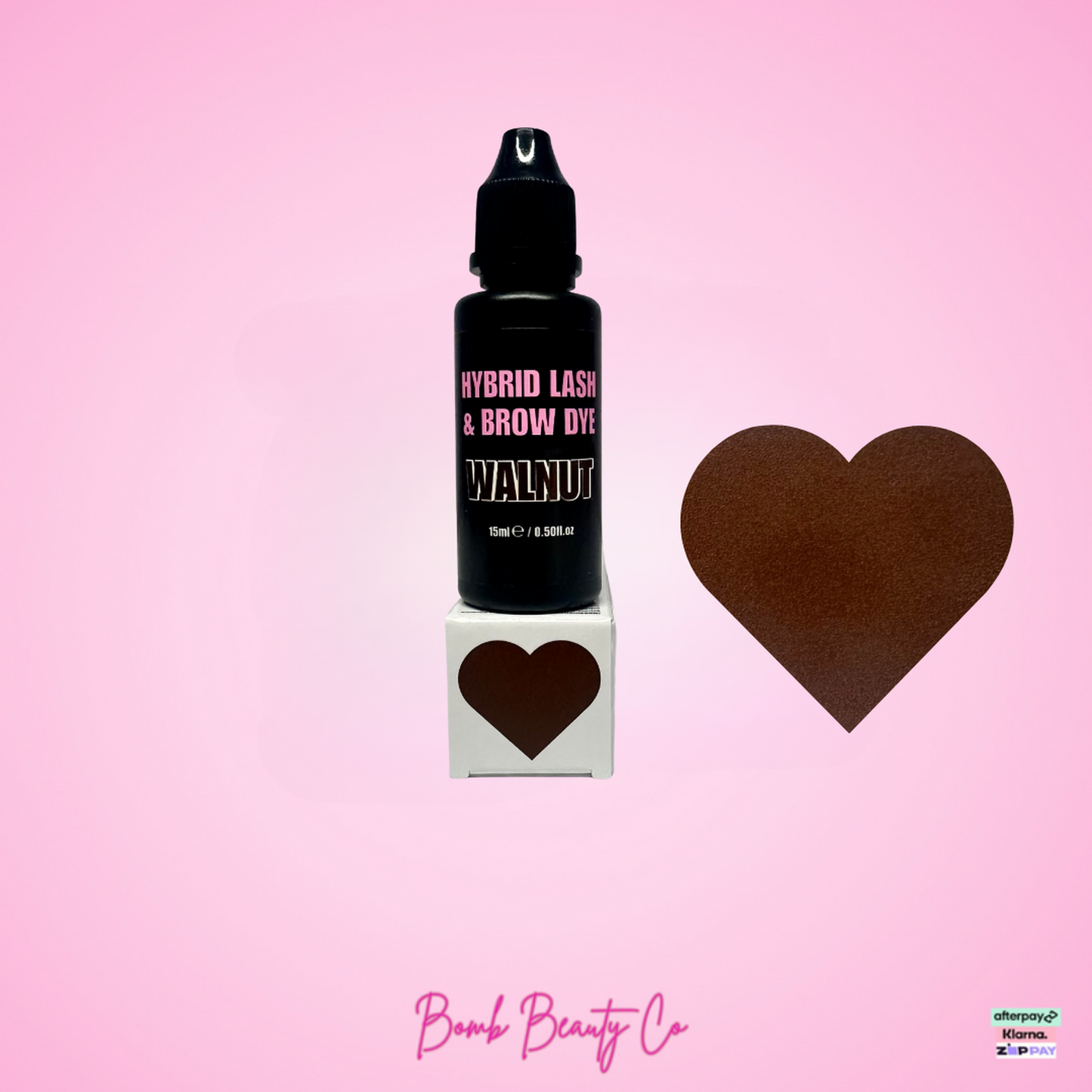 Bottle of Hybrid Lash & Brow Dye with a heart-shaped container and brown heart on pink background, featuring Bomb Beauty Co.
